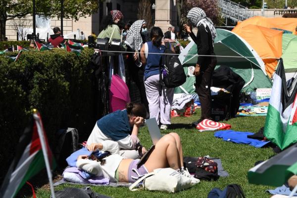 The students show no signs of dispersing as they set up their tents.