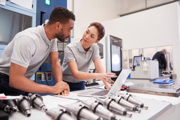 Two Engineers Using CAD Programming Software On Laptop