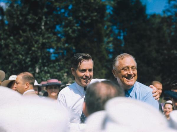 Henry A. Wallace and Franklin Delano Roosevelt embracing in a crowd. 