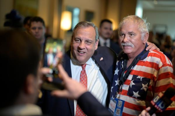 Republican presidential candidate former New Jersey Gov. Chris Christie, center, poses for a photo with an attendee after speaking at the Republican Party of Florida Freedom Summit.