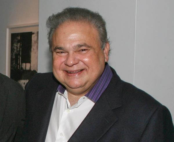 Salomon Melgen in a white open-necked shirt with purple and black striped collar and suit jacket.