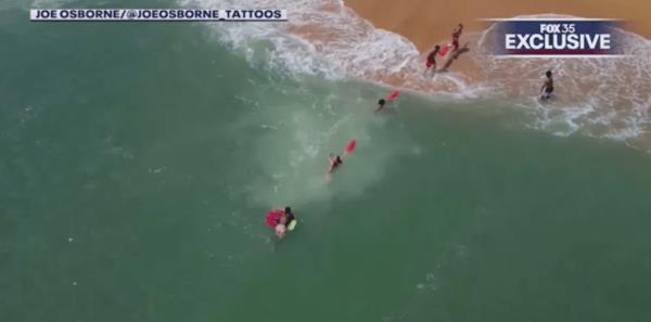 The lifeguards formed a human chain and began towing the boogie boarder to safety.