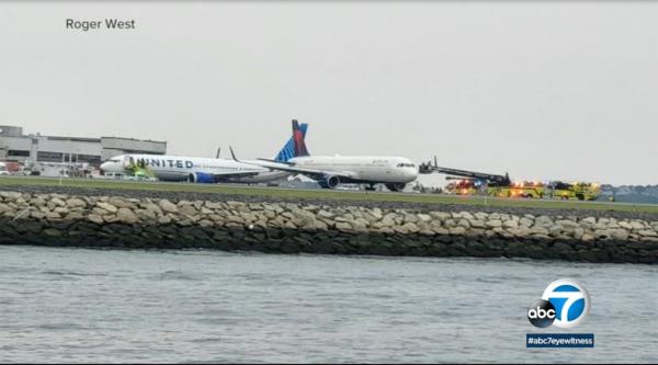 a lo<em></em>ngshot of a Delta plane being towed away at Boston Logan Internatio<em></em>nal Airport.