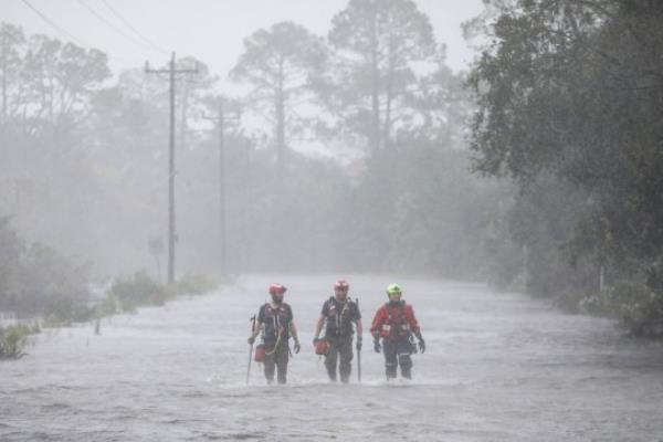 Rescue workers with Tidewater Disaster Respo<em></em>nse wade through a tidal surge on SW 358 Highway while looking for people in need of help after the Steinhatchee River flooded on Wednesday, Aug 30, 2023, in Steinhatchee, Fla., following the arrival of Hurricane Idalia. (Douglas R. Clifford/Tampa Bay Times via AP)