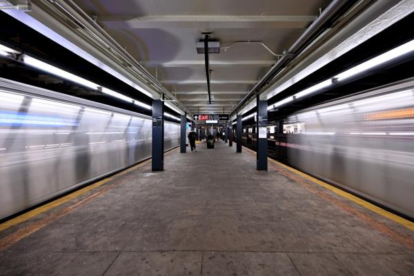 Trains arrive simultaneously on both sides of a central platform at the massive Hoyt-Schemerhorn station. 