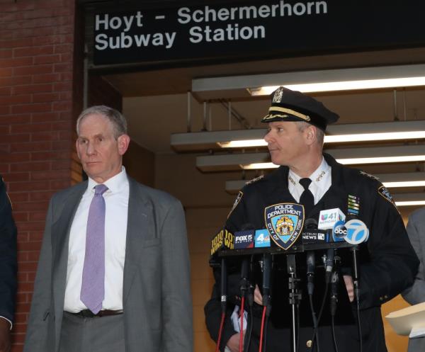 Michael M. Kemper and John Nathan Lieber speaking at a news co<em></em>nference a<em></em>bout a shooting at Hoyt Schermerhorn train station, with police officers present