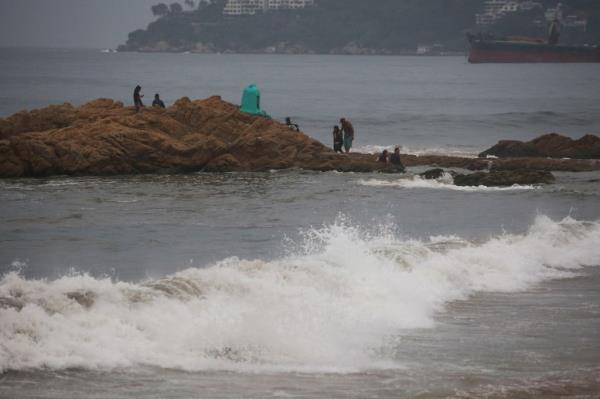 Members of the federal forces chat as they keep watch at a beach as Hurricane Otis barrels towards Acapulco, Mexico.</p>

<p>　　