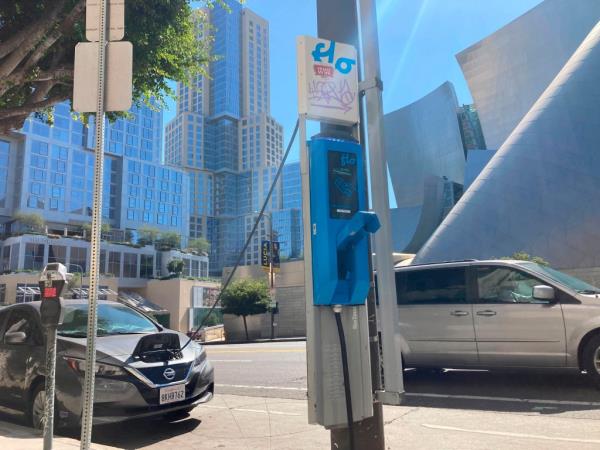  An electric vehicle charges on a publicly accessible pole-mounted charger.