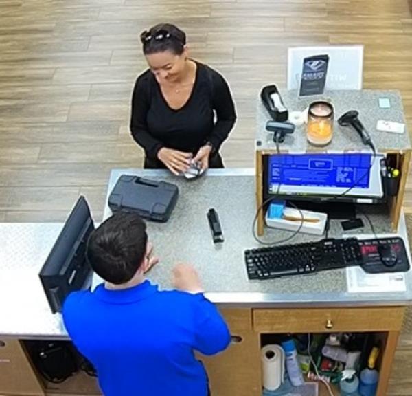 Mica Miller appears to smile at the cashier as she purchases a weapon