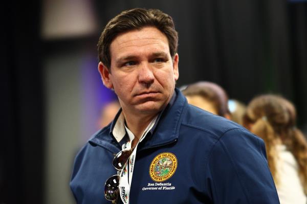 Florida Governor Ron DeSantis attending the NASCAR Cup Series Daytona 500, wearing a blue jacket.