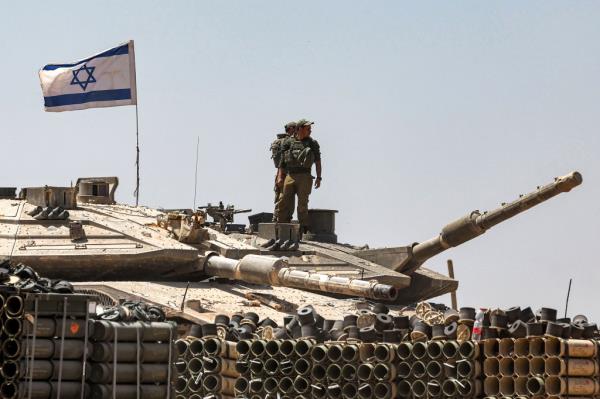 Israeli army soldiers stand atop the turret of a tank positio<em></em>ned in southern Israel near the border with the Gaza Strip on May 9, 2024, amid the o<em></em>ngoing co<em></em>nflict in the Palestinian territory between Israel and the Hamas movement.