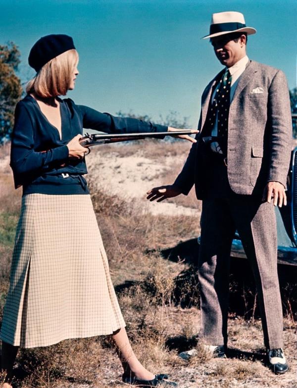 In color, Faye Dunaway points a shotgun at Warren Beatty and reaches for a revolver on his belt. Their outfits are modeled on the original Bo<em></em>nnie and Clyde photo, although Dunaway wears a light skirt. 