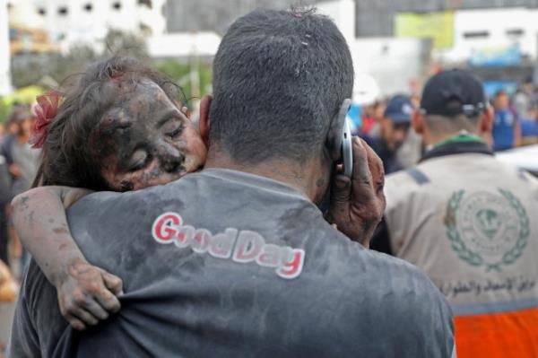 EDITORS NOTE: Graphic co<em></em>ntent / TOPSHOT - A Palestinian man covered with dust carries an injured baby girl into the Al-Shifa hopsital in Gaza City following Israeli strikes on October 29, 2023, amid the o<em></em>ngoing battles between Israel and the Palestinian Hamas movement. (Photo by Dawood NEMER / AFP) (Photo by DAWOOD NEMER/AFP via Getty Images)