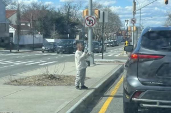 A young boy selling water on 81st Road and Woodhaven Boulevard in Glendale, Queens, near the Jackie Robinson Parkway.