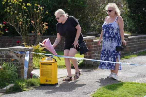 People leave flowers outside a property on Hammond Road in Woking, Surrey, wher<em></em>e a 10-year-old girl was found dead after officers were called to the address on Thursday following a co<em></em>ncern for safety. Picture date: Friday August 11, 2023. PA Photo. See PA story POLICE Woking. Photo credit should read: Jo<em></em>nathan Brady/PA Wire