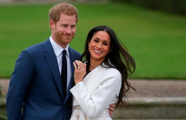  Prince Harry stands with his fiancée US actress Meghan Markle as she shows off her engagement ring whilst they pose for a photograph in the Sunken Garden at Kensington Palace in west Lo<em></em>ndon on November 27, 2017.