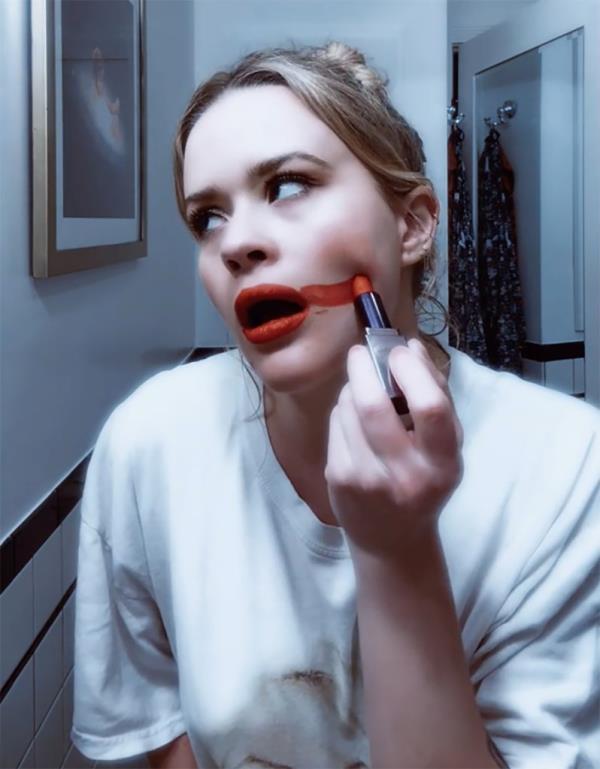 Ava Philippe smearing red lipstick on her cheek 