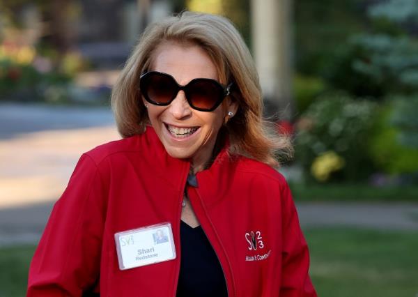 Shari Redstone smiling while standing outside in a red jacket.