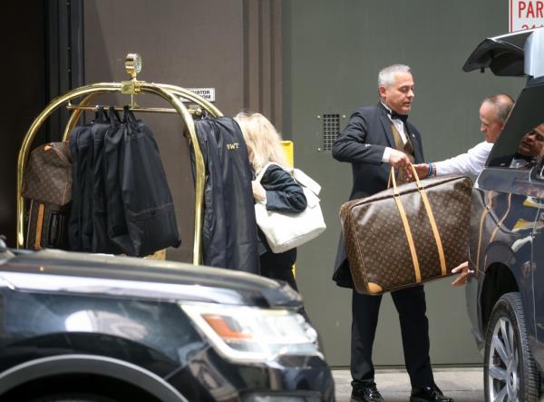 A doorman holds the Louis Vuitton luggage.