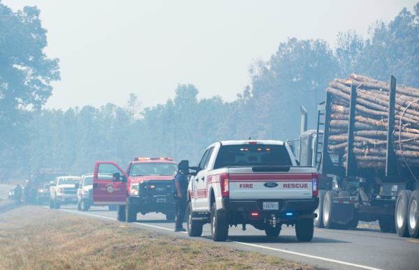 Timber trucks and fire perso<em></em>nnel occupy Highway 27 while helping fight a wildfire.