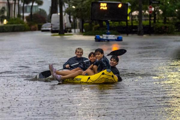 People sit in a raft during the Fla. floods.