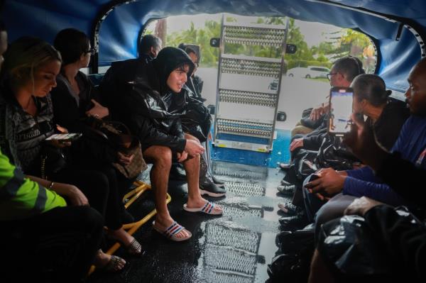 People sit in a search and rescue truck amid the flooding.