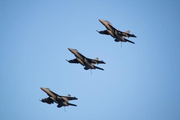 Super Hornets attached to Carrier Air Wing (CVW) 8 fly in formation over the world's largest aircraft carrier USS Gerald R. Ford's (CVN 78) flight deck in the Eastern Mediterranean Sea, October 13, 2023.