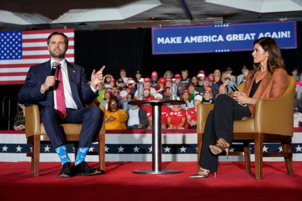 Republican vice president nominee Sen. JD Vance speaking at a campaign event in Greensboro, while moderator Danica Patrick listens attentively.