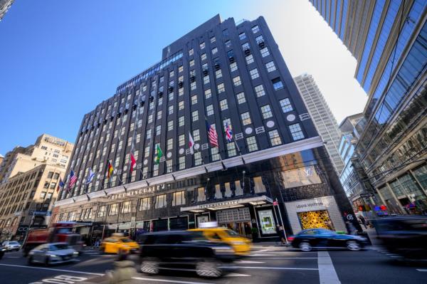 Bloomingdale's superstore building with lots of windows and cars parked on the street in New York City.