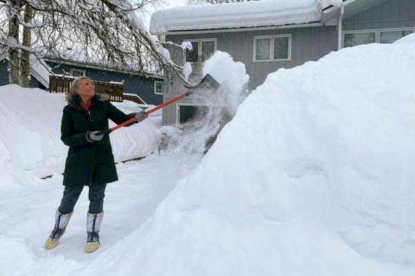 A woman shoveling snow. 