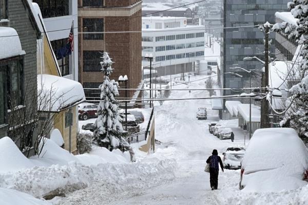 A man walking down a snowy street. 