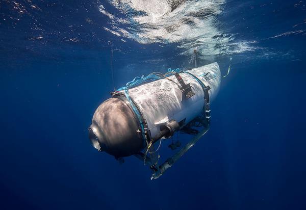 A submarine descending into the sea, co<em></em>nnected by a blue rope for a Titanic exploration expedition