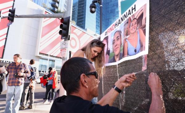 Volunteers put up flyers of missing Maui woman Hannah Kobayashi outside Crypto.com Arena in Downtown Los Angeles Thursday.