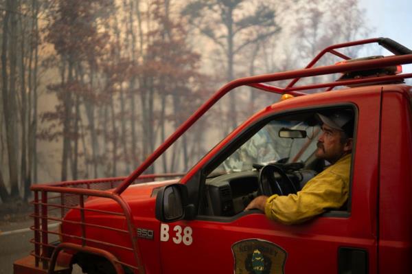 Firefighters, including Jake Roberts, respo<em></em>nding to a forest fire in Evesham, New Jersey on November 6, 2024, with a red truck on the scene.