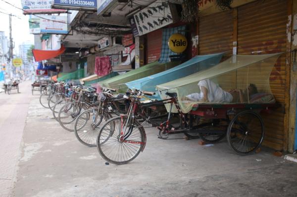 Homeless people sleep on vans inside mosquito-nets to protect them from mosquito-borne disease in Dhaka, Bangladesh.