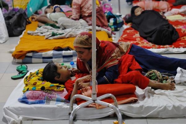 A mother takes care of her dengue-infected child after being hospitalised for treatment.