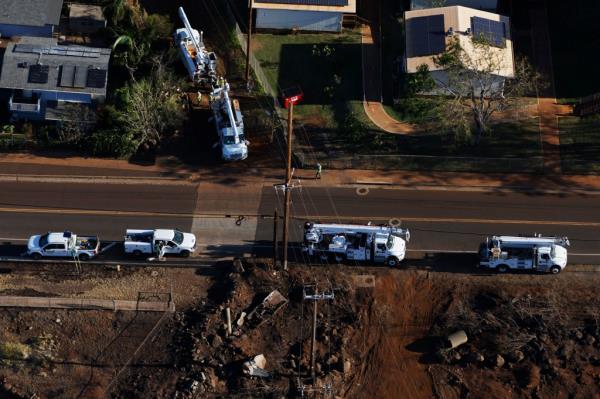 Utility crews work on a power line along 