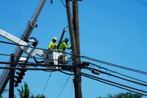 Linemen work on poles 