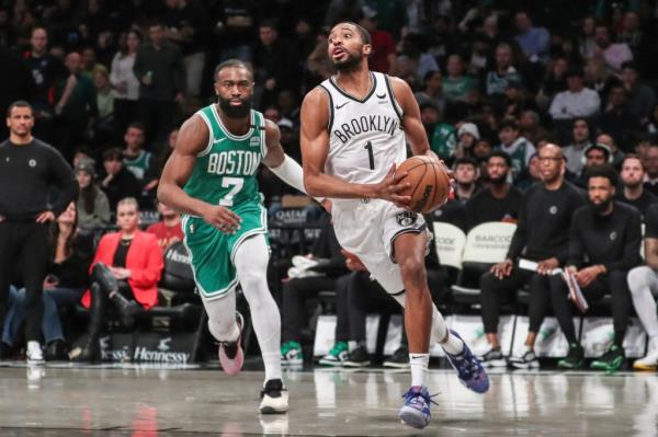 Mikal Bridges drives past Jaylen Brown.