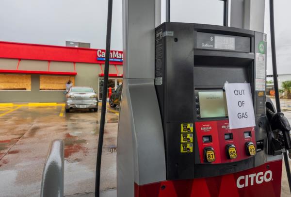 Crews boarding up windows of the Cash Magic gas station, which ran out of gas, in preparation for Hurricane Francine in Houma, Louisiana.