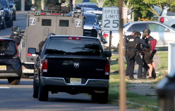 SWAT officers taking a red-haired woman into custody outside a Ravenwood Drive home