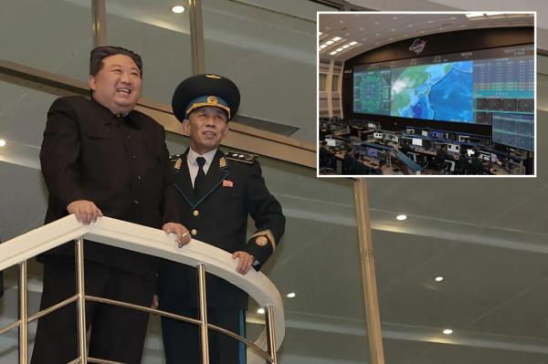 Kim Jong Un (C) and his daughter (2nd L-front) posing with scientists who co<em></em>ntributed to the launch of a reco<em></em>nnaissance satellite, at the Natio<em></em>nal Aerospace Technology Directorate in Pyongyang.