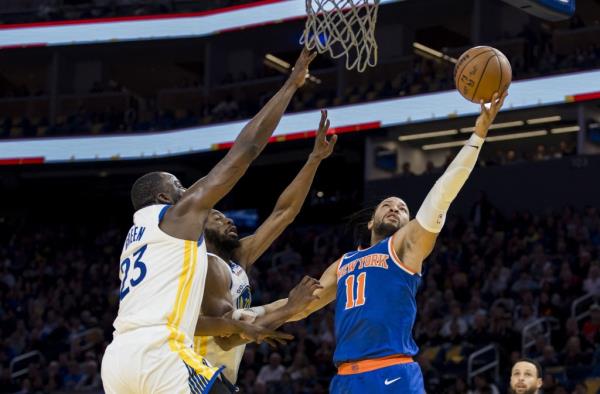 Jalen Brunson goes up for a layup as Draymond Green (left) and Andrew Wiggins defend during the Knicks' win. 