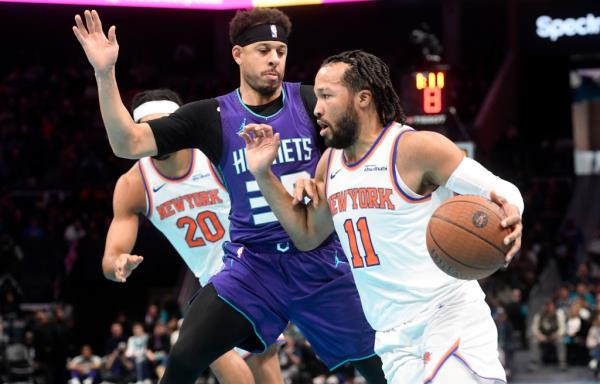 Knicks guard Jalen Brunson (11) drives past Charlotte Hornets guard Seth Curry (30)