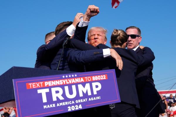 Former President Do<em></em>nald Trump, the republican presidential candidate, surrounded by U.S. Secret Service agents, gesturing at a campaign rally in Butler, Pa on July 13, 2024