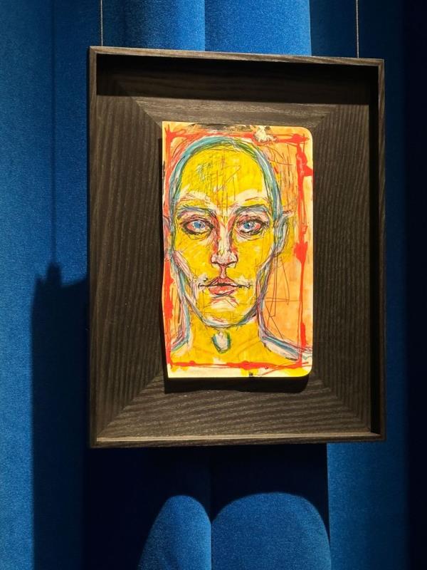 A painting of a hairless, yellow head