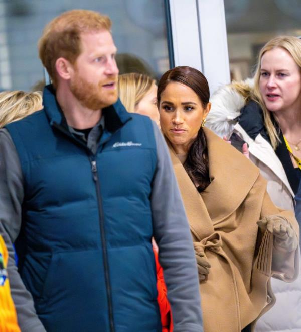 Prince Harry and Meghan Markle smiling while playing curling at the Vancouver Curling Club.