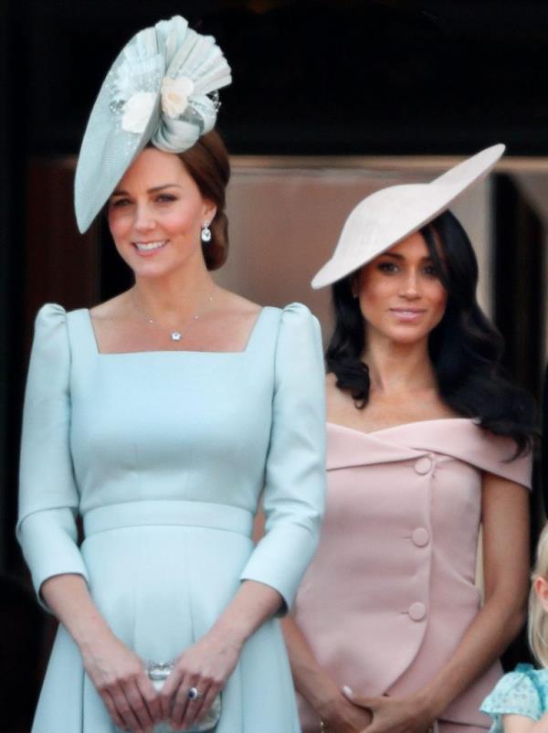 Catherine, Duchess of Cambridge and Meghan, Duchess of Sussex standing on a balcony wearing hats, during Trooping The Colour ceremony.