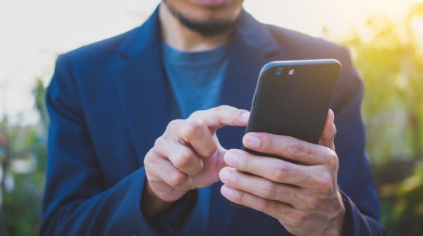 A man holding and using a smartphone for internet communication services