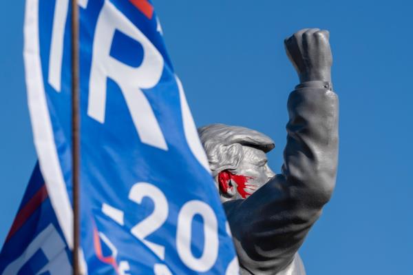 Statue of former President Do<em></em>nald Trump on a truck at the Butler Farm Show, fist raised in front of a flag